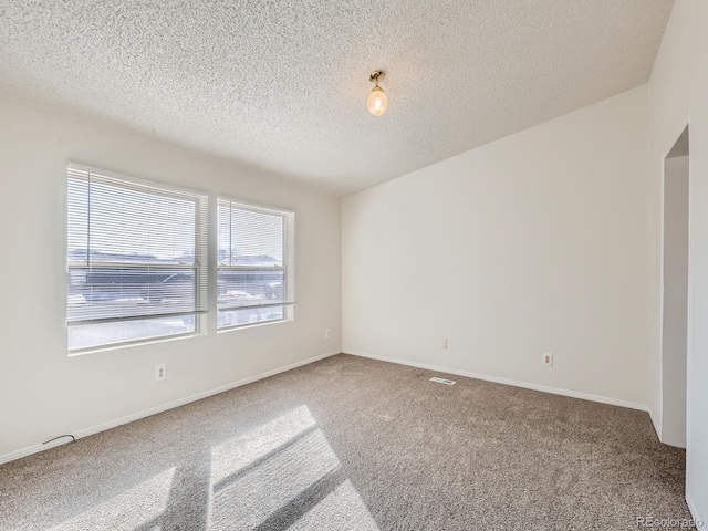 carpeted spare room featuring a textured ceiling