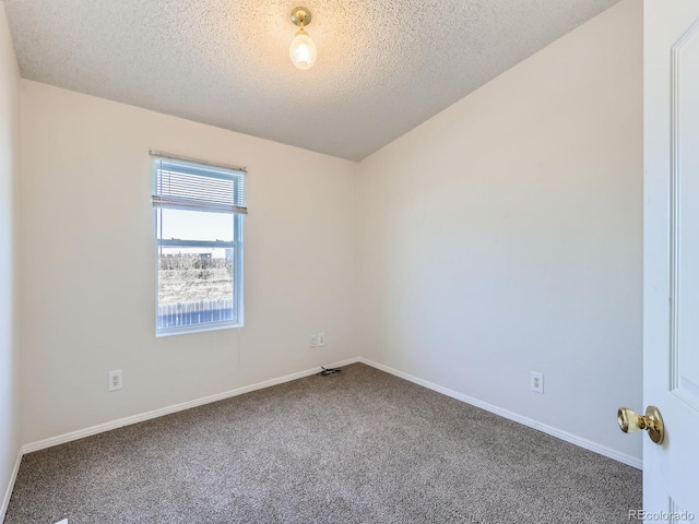 carpeted empty room featuring a textured ceiling