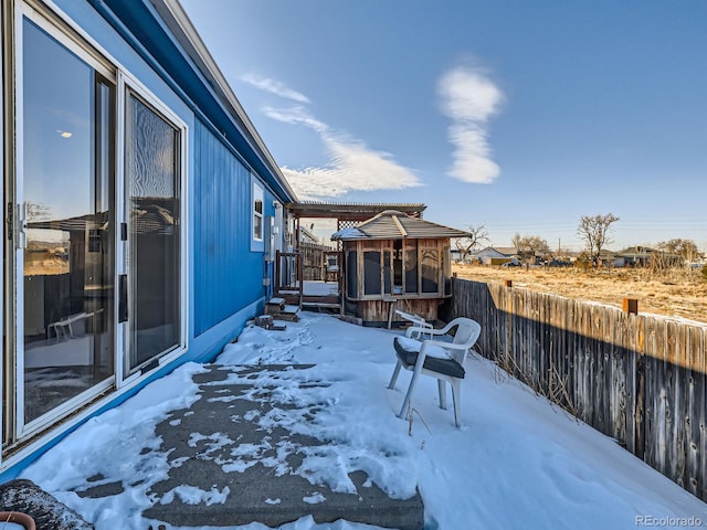 yard layered in snow with a pergola