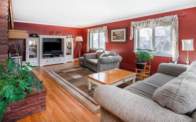 living room with ornamental molding, a baseboard heating unit, and hardwood / wood-style floors