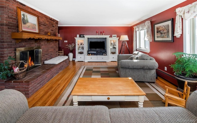 living room featuring a brick fireplace, crown molding, and dark hardwood / wood-style floors