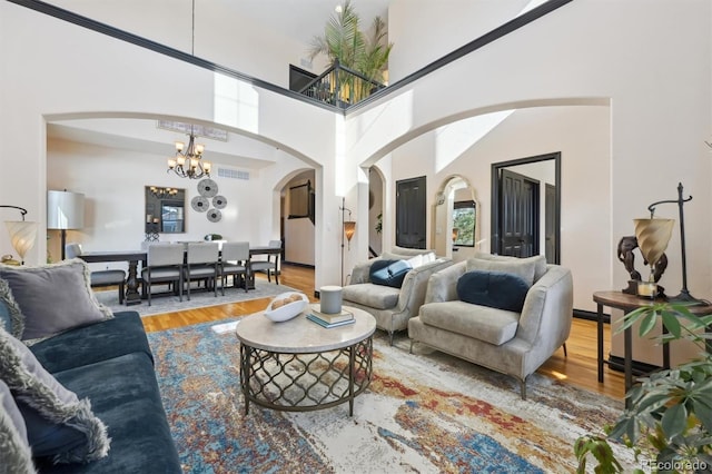 living room with a high ceiling, wood-type flooring, and a chandelier