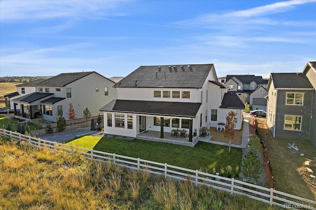 back of house with a patio and a yard