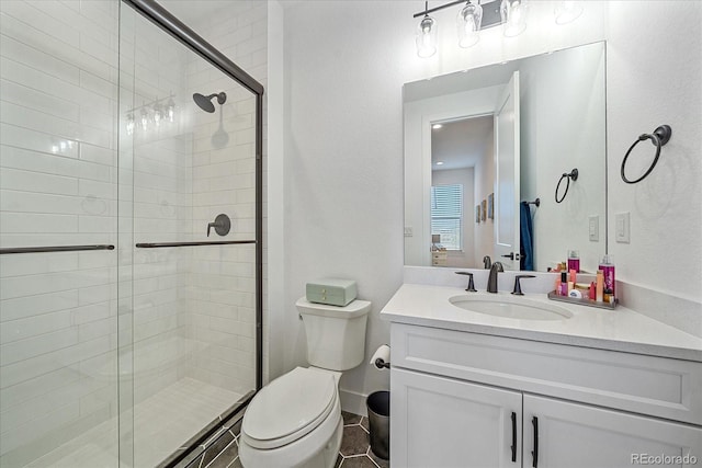 bathroom with toilet, a shower with shower door, vanity, and tile patterned floors