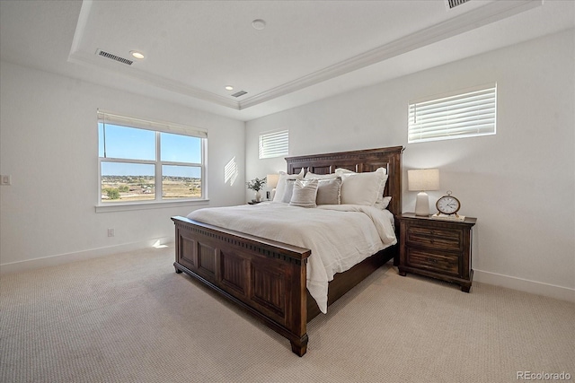 bedroom featuring light carpet, ornamental molding, and a raised ceiling