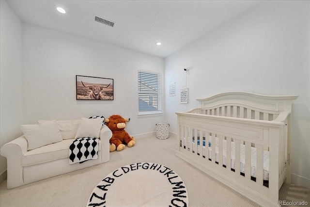 carpeted bedroom with a nursery area