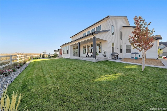 back of property with a patio area and a yard