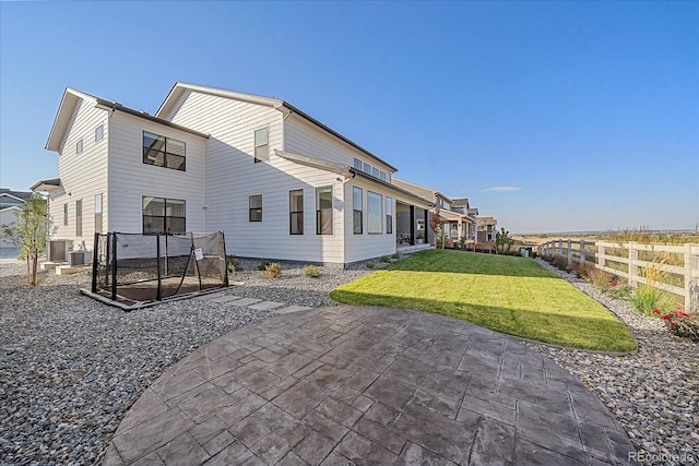 back of house featuring central AC unit, a patio, and a lawn