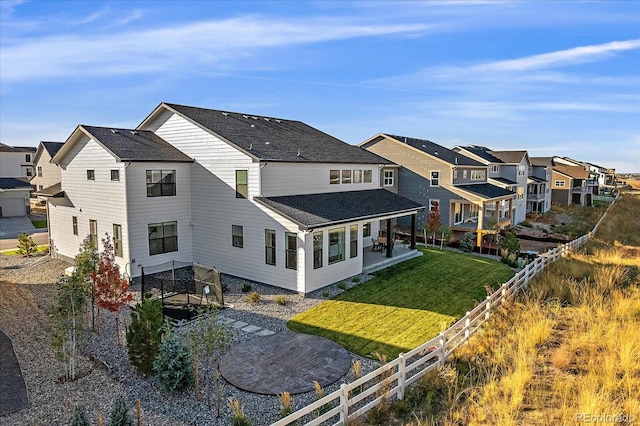 back of property with a yard and a patio area