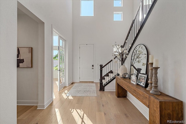 entrance foyer featuring light hardwood / wood-style floors and a towering ceiling