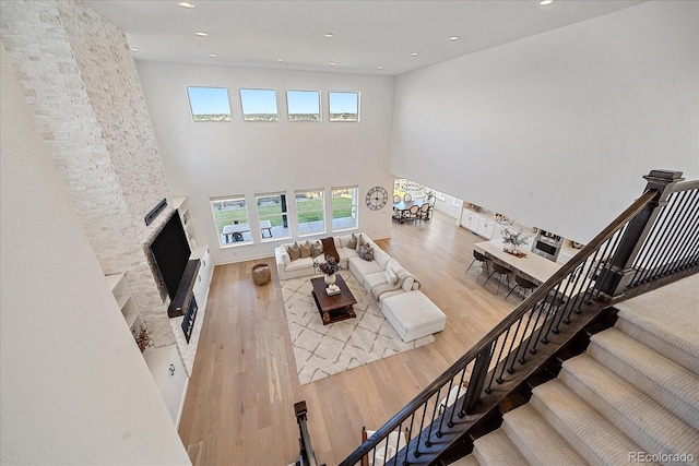 living room with a high ceiling, hardwood / wood-style flooring, and plenty of natural light