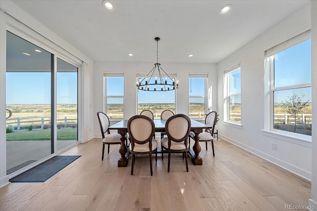 dining room featuring light hardwood / wood-style floors, a wealth of natural light, and a chandelier