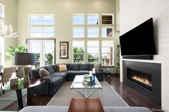 10243 Spring Green Dr, Englewood, CO 80112 - living area with wood-type flooring, a fireplace, a towering ceiling, and a chandelier