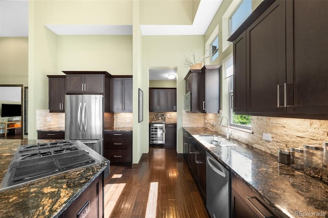 10243 Spring Green Dr, Englewood, CO 80112 - kitchen featuring stainless steel appliances, wine cooler, dark stone counters, dark brown cabinets, and dark wood-style floors