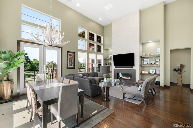 10243 Spring Green Dr, Englewood, CO 80112 - dining space featuring a towering ceiling, hardwood / wood-style flooring, a fireplace, a chandelier, and recessed lighting