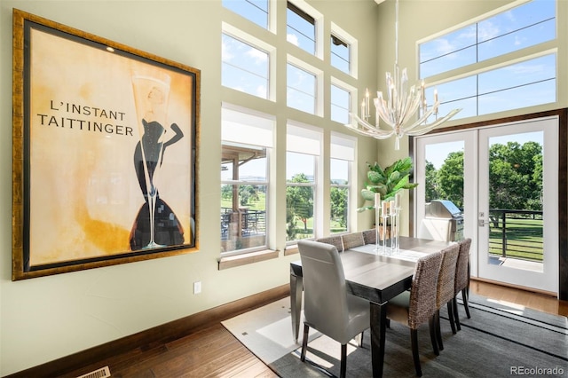 10243 Spring Green Dr, Englewood, CO 80112 - dining space with a chandelier, dark wood-type flooring, a high ceiling, and french doors
