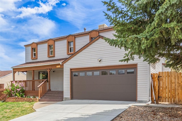 traditional-style house featuring covered porch, an attached garage, fence, and concrete driveway