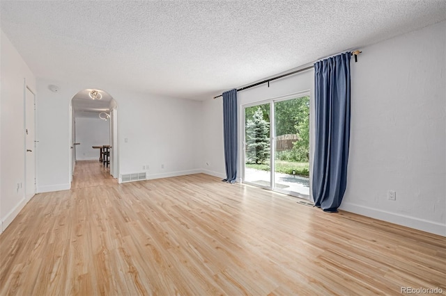 4808 S Ward Way, Morrison, CO 80465 - spare room with arched walkways, light wood finished floors, and a textured ceiling