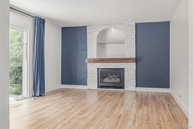 4808 S Ward Way, Morrison, CO 80465 - unfurnished living room with wood finished floors, a textured ceiling, and a fireplace