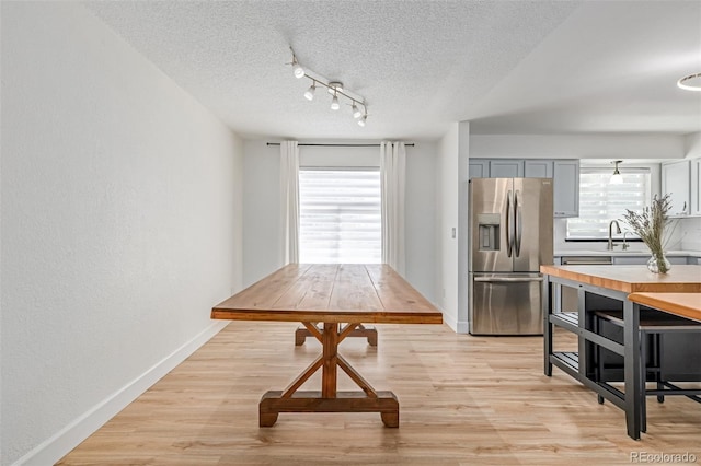 4808 S Ward Way, Morrison, CO 80465 - dining room featuring a textured ceiling, healthy amount of natural light, light wood-style floors, and rail lighting