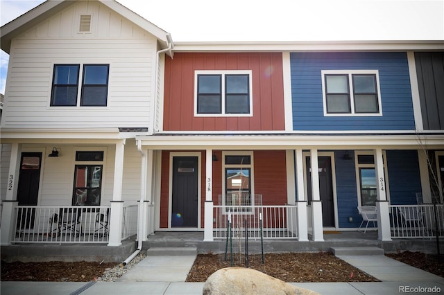 townhome / multi-family property with board and batten siding and covered porch