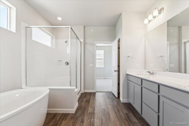 1281 Loraine Cir N, Lafayette, CO 80026 - full bathroom featuring vanity, a shower stall, a freestanding bath, and wood finished floors
