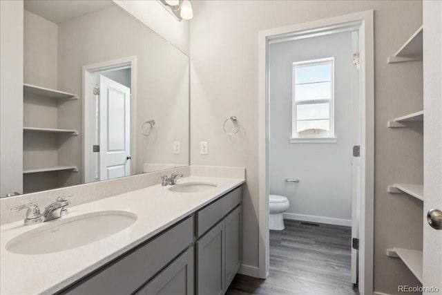 1281 Loraine Cir N, Lafayette, CO 80026 - full bath with double vanity, toilet, wood finished floors, and baseboards