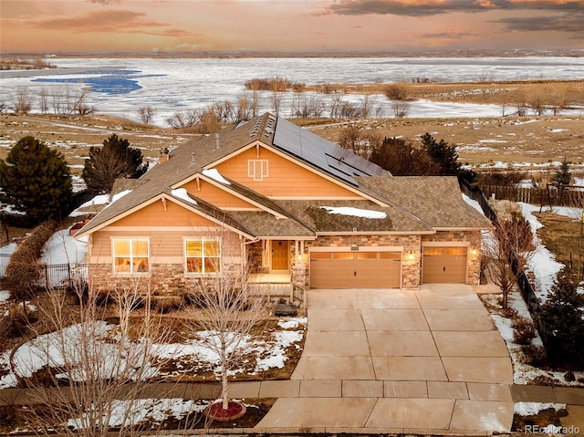 view of front of property with a garage and solar panels