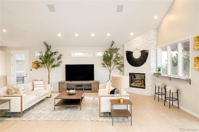 living room with a fireplace, light hardwood / wood-style floors, and vaulted ceiling