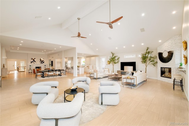 living room featuring light hardwood / wood-style flooring, beam ceiling, a fireplace, and high vaulted ceiling