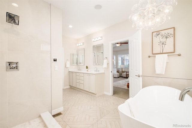 bathroom with vanity, a tub, and ceiling fan