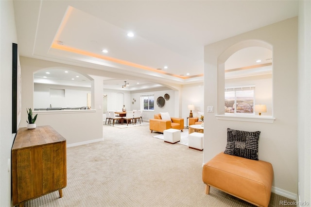 carpeted living room with a tray ceiling