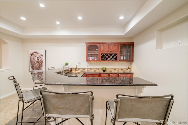 bar with light colored carpet, a tray ceiling, and sink