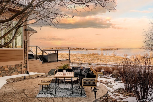 snow covered patio with a water view