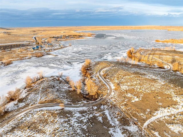 snowy aerial view featuring a water view