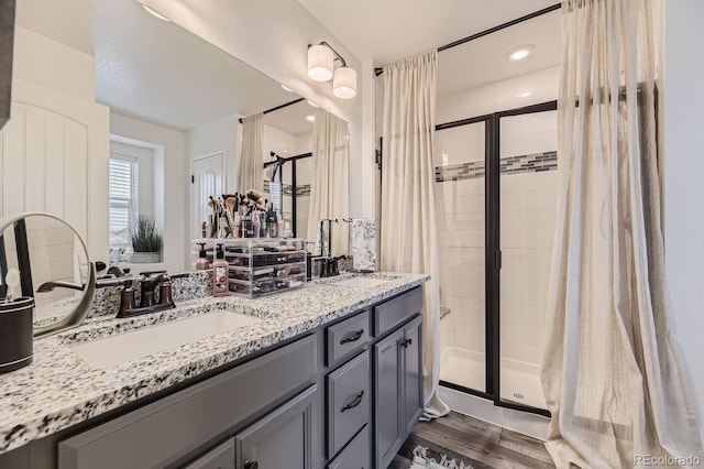 bathroom with vanity, hardwood / wood-style flooring, and walk in shower