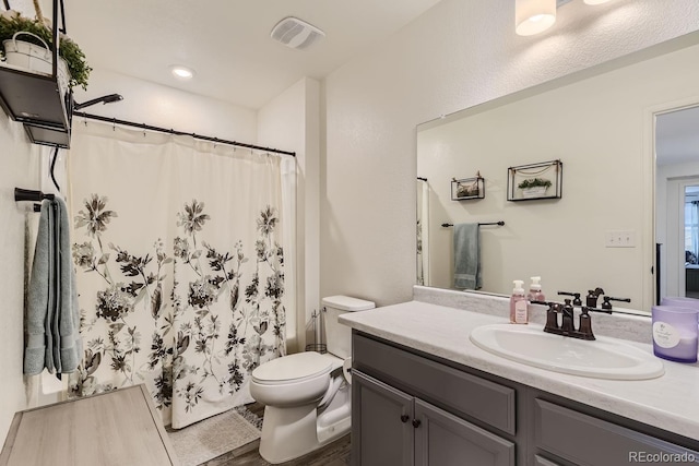 bathroom with vanity, toilet, curtained shower, and hardwood / wood-style floors