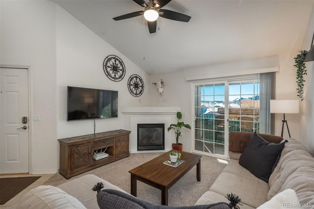 carpeted living room with a tile fireplace, high vaulted ceiling, and ceiling fan