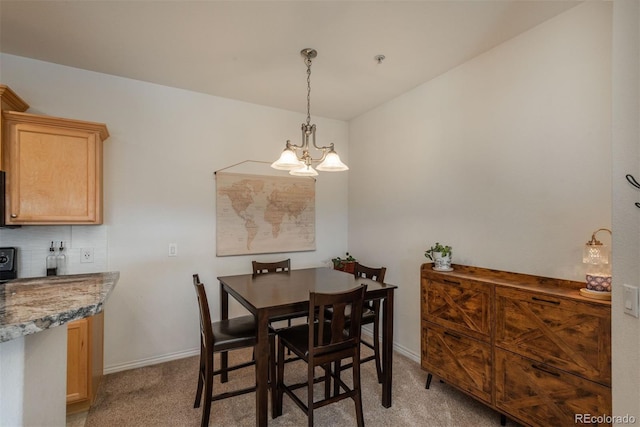 dining room with a chandelier and light carpet