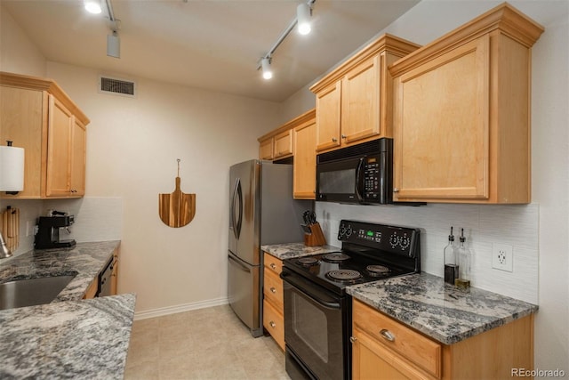 kitchen with sink, dark stone countertops, track lighting, light brown cabinetry, and black appliances