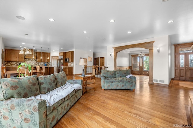 1195 W 70th Ave, Denver, CO 80221 - living area featuring recessed lighting, a chandelier, arched walkways, and light wood finished floors