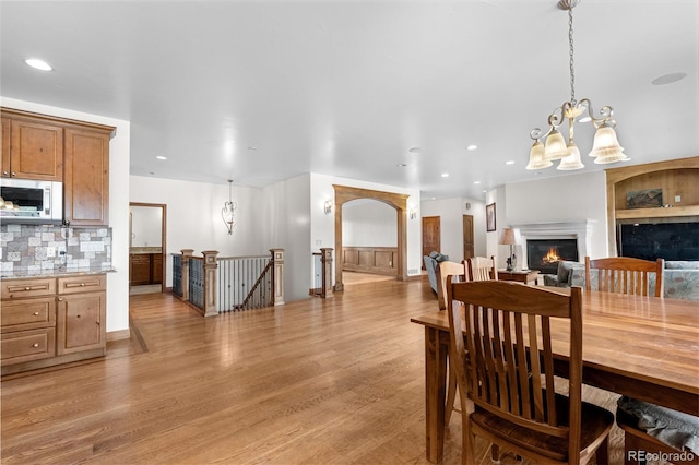 1195 W 70th Ave, Denver, CO 80221 - dining area with a lit fireplace, light wood-type flooring, a chandelier, and recessed lighting