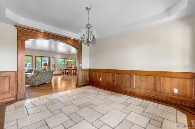 1195 W 70th Ave, Denver, CO 80221 - unfurnished room featuring a chandelier, wainscoting, a raised ceiling, stone tile flooring, and recessed lighting