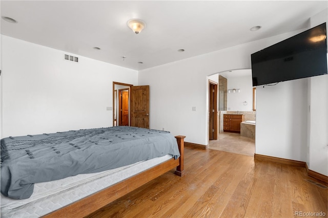 1195 W 70th Ave, Denver, CO 80221 - bedroom with arched walkways and light wood-style flooring