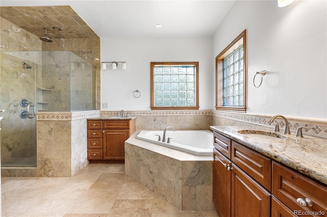 1195 W 70th Ave, Denver, CO 80221 - full bathroom with two vanities, a shower stall, a garden tub, tile walls, and wainscoting