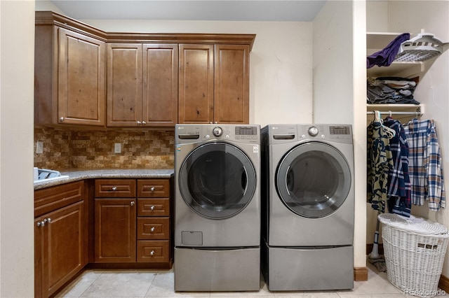 1195 W 70th Ave, Denver, CO 80221 - laundry area featuring cabinet space, washing machine and clothes dryer, and light tile patterned flooring