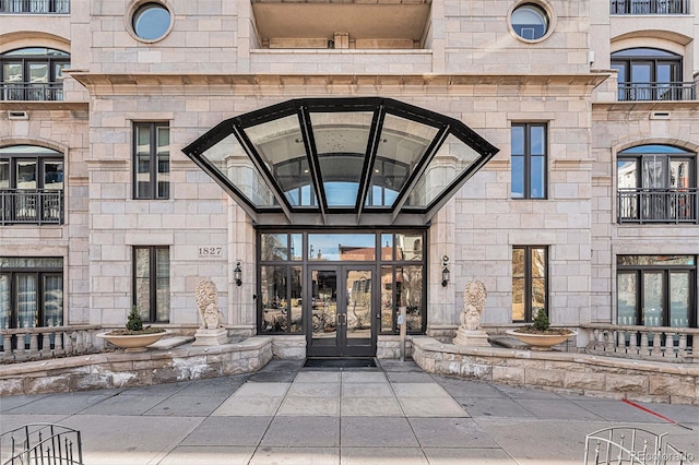 view of exterior entry with stone siding and french doors