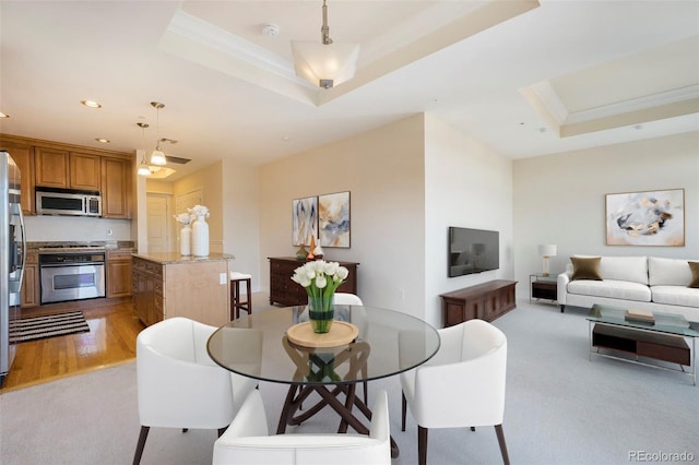 dining area featuring light carpet, a tray ceiling, crown molding, and recessed lighting