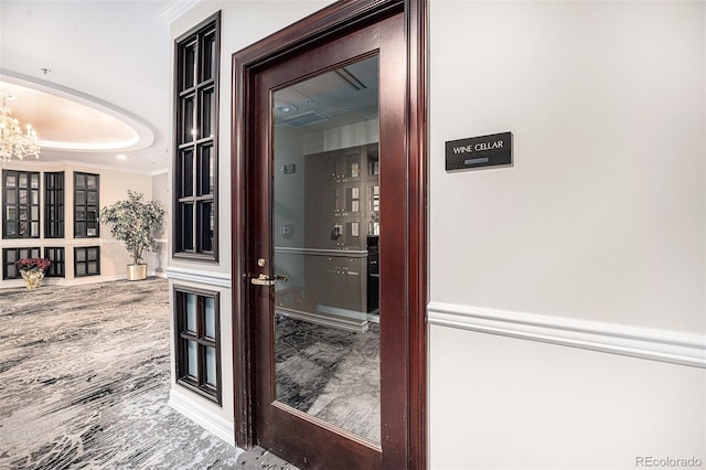 interior space with a notable chandelier, crown molding, and wood finished floors