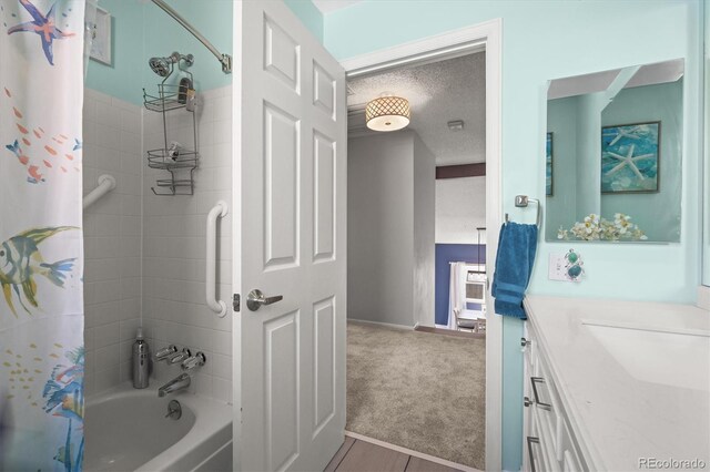 8815 W Quarto Cir, Littleton, CO 80128 - full bath with shower / bath combination with curtain, vanity, a textured ceiling, and baseboards